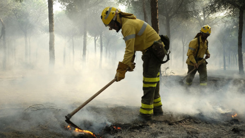 Bomberos trabajan en los alrededores de Mazagón, en Huelva, en el incendio que ha obligado a desalojar a más de 2.000 personas y que continúa acechando el Espacio Natural de Doñana. EFE/Julián Pérez