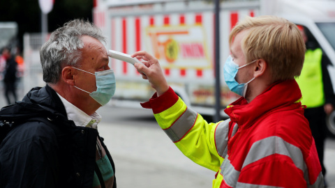 Personal de salud mide la temperatura a un hombre este sábado en Berlín. REUTERS/Hannibal Hanschke