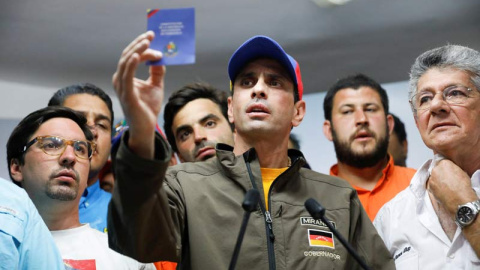 Henrique Capriles sostiene un ejemplar de la Constitución Bolivariana de Venezuela durante un acto de la oposición. | REUTERS