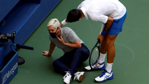 Novak Djokovic de Serbia intenta ayudar a una jueza de línea después de golpearla con una pelota en la garganta durante su partido contra Pablo Carreño en el US Open Tennis. EFE / EPA / JASON SZENES