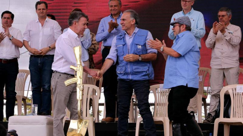 El presidente de Colombia, Juan Manuel Santos, el jefe de la Misión de la ONU en Colombia, Jean Arnault, y el líder de las FARC, 'Timochenko', en el acto de entrega de armas. /EFE