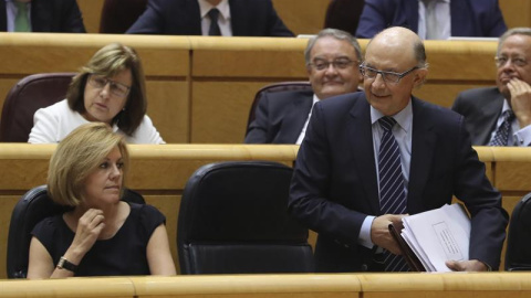 El ministro de Hacienda, Cristóbal Montoro y la titular de Defensa, María Dolores de Cospedal, durante la sesión de control al Gobierno en el pleno del Senado. /EFE