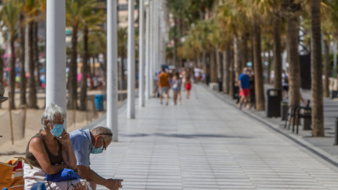 Dos personas descansan en el paseo marítimo de Benidorm, Alicante el 27 de septiembre de 2020. Lars Ter Meulen / Europa Press