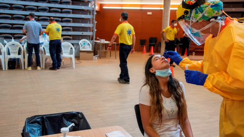 Una joven es atendida por un profesional sanitario para hacer una PCR. EFE/ Ramon Gabriel/Archivo