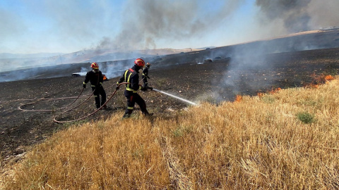 01/08/2020.- Efectivos del cuerpo de bomberos trabajan en las labores de extinción del incendio de cereal y pasto originado en la localidad madrileña de Valdepiélagos, que ha obligado a desalojar la urbanización Lago del Jaral, ya en territorio de Gua