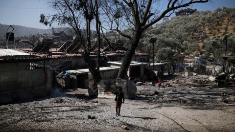 Un niño observa los restos del campo de refugiados de Moria tras el incendio.- REUTERS