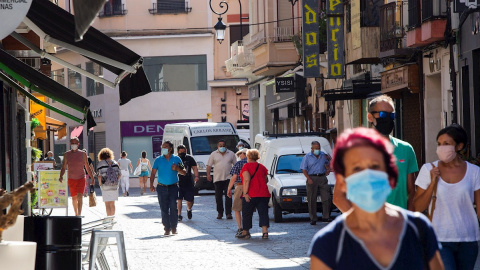 Varias personas protegidas con mascarilla caminan este lunes por la calle más comercial de Aranda. La zona básica de salud de Aranda de Duero (Burgos) presenta este lunes 49 casos de Covid-19. EFE/ Pacosantamaria