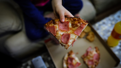 Un niño de la Comunidad de Madrid comiendo Telepizza a través de los servicios contratados por el Gobierno regional para las familias  perceptoras de Renta Mínima de Inserción (RMI) durante el confinamiento. / EUROPA PRESS