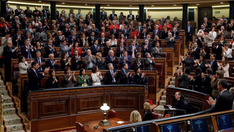 Los diputados del PSOE y de Unidas Podemos (d) se aplauden mutuamente tras las intervenciones de los portavoces del grupo de Unidas Podemos ante el pleno del Congreso de los Diputados en la primera jornada de la sesión de investidura de Pedro Sánchez co