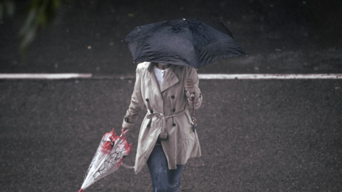 Una persona camina bajo la lluvia protegida con un paraguas, en Madrid (España) a 24 de septiembre de 2020.  Óscar Cañas / Europa Press