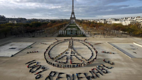 Activistas medioambientales forman el símbolo de la paz cerca de la Torre Eiffel en París, en diciembre de 2015, durante la celebración de la Cumbre del Clima en la capital francesa. REUTERS