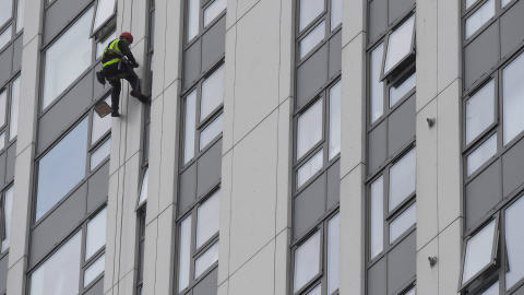 Un desciende por una de las fachadas de la Bray Tower para revisar su revestimiento. REUTERS / Toby Melville