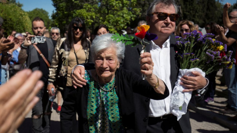 La lucha de una vida. Ascensión levanta unas flores con los colores republicanos junto a su hijo.- REUTERS