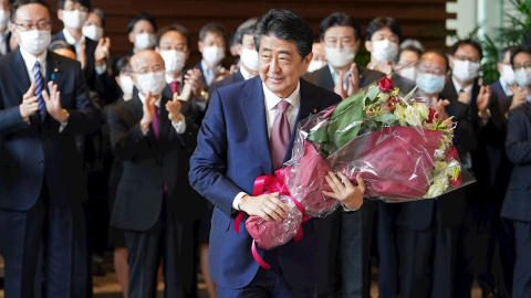 El primer ministro saliente de Japón, Shinzo Abe, sostiene un ramo a su salida de la residencia oficial del primer ministro en Tokio. EFE / EPA / JIJI PRESS JAPAN OUT