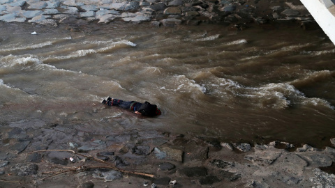 Un manifestante yace en el río después de caer de un puente durante una protesta contra el Gobierno de Chile, en Santiago. REUTERS.