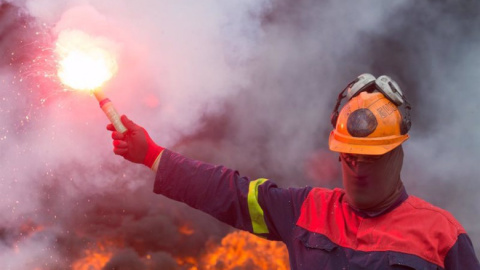 Un trabajador de Alcoa San Cibrao enciende una bengala durante una manifestación / EP