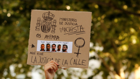 La imagen de los cinco miembros de la llamada Manada, en una pancarta sostenida por una manifestante en una protesta en Sevilla en junio de 2018. REUTERS/Marcelo del Pozo