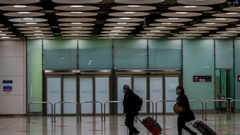 Dos personas en el aeropuerto de Barajas en Madrid / EFE