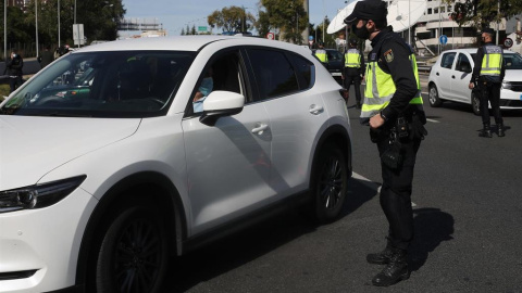 Un agente de la Policía Nacional habla con un conductor durante un control policial de movilidad en Madrid. - EUROPA PRESS