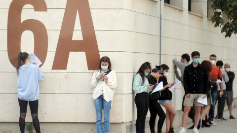 Alumnos de la Universidad Politécnica de Valencia (UPV) guardan cola en el exterior de las instalaciones del pabellón de baloncesto donde se realizan pruebas PCR. EFE/Kai Försterling