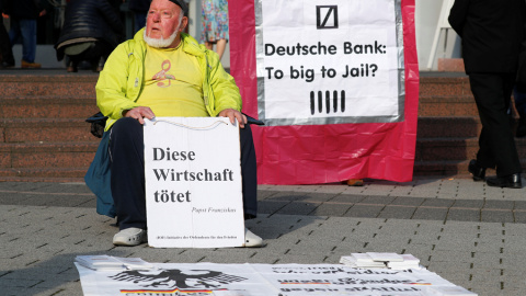 Un manifestante protesta en el exterior de la junta de accionistas de Deutsche Bank, en Fráncfort, con un cartel que dice "Esta economía mata. El Papa Francisco". REUTERS / Kai Pfaffenbach