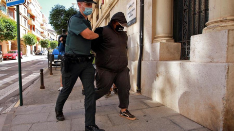 Un agente de la Guardia Civil traslada al Juzgado de Instrucción número 1 de Ontinyent, en Valencia, a uno de los detenidos por su supuesta participación en una violación grupal a una menor de 14 años en la localidad valenciana de l'Olleria que se pr