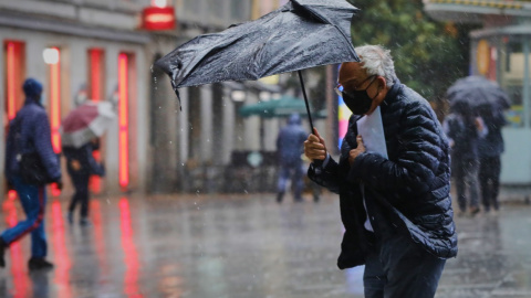 Una persona camina por el centro de la capital en una jornada marcada por las lluvias y la bajada de temperaturas, en Madrid. Jesús Hellín / Europa Press