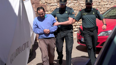 El hijo de la mujer hallada muerta en el domicilio familiar en la localidad de Pozondón, acompañado por agentes de la Guardia Civil. EFE