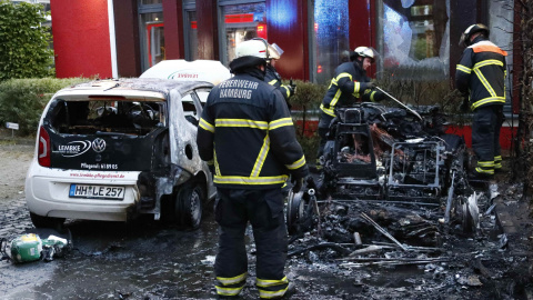 Los Bomberos de Hamburgo apagan las llamas de un coche calcinado, /REUTERS