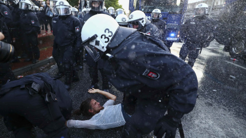 Varios agentes antidisturbios cargan contra un manifestante en Hamburgo. /REUTERS