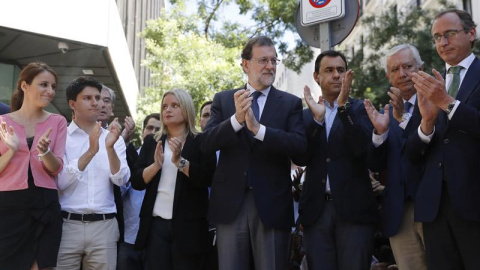 El presidente del Gobierno y del PP, Mariano Rajoy, junto a Marimar Blanco y otros dirigentes del PP en el despliegue de la pancarta en la sede del partido. | JUAN CARLOS HIDALGO (EFE)