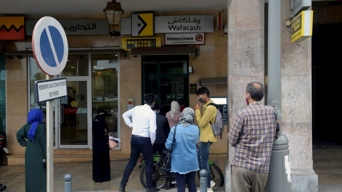 Gente haciendo cola ante una oficina de remesas en Rabat. - EFE