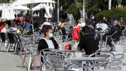 Varios clientes conversan en la terraza de un bar en el madrileño barrio de Aluche, en una imagen de archivo. EFE/Kiko Huesca