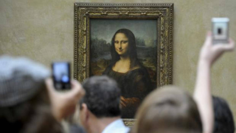 Un grupo de turistas fotografía 'La Gioconda' en el Museo del Louvre, en París.- EFE