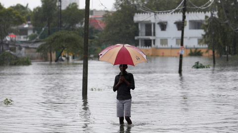 Un hombre sujeta un paraguas en una inundación en Colombo, Sri Lanka./ REUTERS