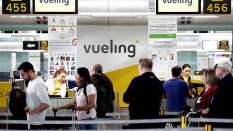 Un grupo de pasajeros ante un mostrador de facturacion de Vueling en el Aeropuerto de Barcelona-El Prat. / EFE