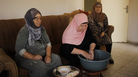 Karemeh Ahmad (izquierda) junto a sus compañeras preparando el trigo para hacer cuscús, 16 de agosto de 2019. /Marta Saiz