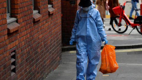 Una mujer camina protegida contra la covid.  REUTERS/Toby Melville