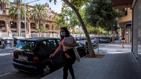 Una mujer con mascarilla camina por la avenida del Arquitecte Bennàssar en Palma, donde el Govern ha anunciado nuevas medidas para contener los contagios | EFE