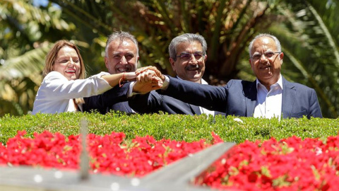 22/06/2019.- Los líderes del PSOE, Podemos Canarias, Nueva Canarias y Asamblea Socialista Gomera, Ángel Víctor Torres (2i); Noemí Santana (i), Román Rodríguez (2d) y Casimiro Crubelo (d), juntan sus manos tras firmar el acuerdo de gobernabilidad par