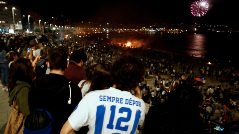 Un grupo de jóvenes disfruta de la noche de San Juan en torno a las hogueras que iluminaron las playas de A Coruña | EFE