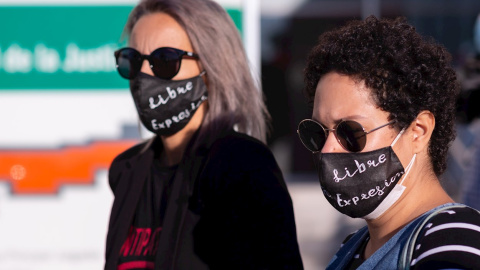 14/10/2020.- Dos mujeres con mascarillas a las puertas de la Ciudad de la Justicia de Málaga, antes de comenzar hoy el juicio contra una mujer tras participar en la "Gran procesión del Santo chumino rebelde" el 8 de marzo de 2013. / EFE - Carlos Díaz