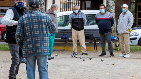 Un grupo de personas juega a la petanca en Zaragoza, donde los parques y zonas de esparcimiento al aire libre permanecerán abiertos con las medidas de prevención y protección individual adecuadas. EFE/ Javier Belver