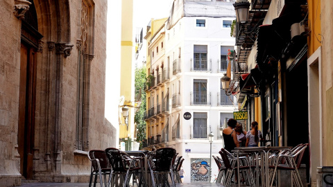 La terraza vacía de un bar frente al edificio de La Lonja, en el centro histórico de Valéncia. EFE/Manuel Bruque