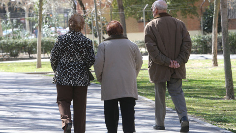 Pensionistas paseando por un parque.