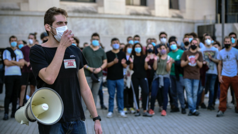 Un joven del Front Estudiantil Unificat (FEU) habla a través de un megáfono en una concentración junto a la Facultat de Medicina de València durante la huelga de la comunidad universitaria y de centros de investigación contra la precariedad en la ens