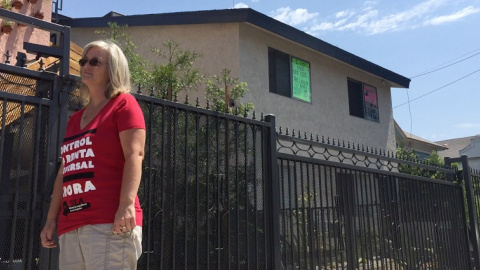 La directora de “Unión de Vecinos”, Elizabeth Baley, posa frente al edificio de apartamentos donde Luis Valdivia lleva más de dos décadas viviendo. Crédito: Aitana Vargas (4/8/2017)