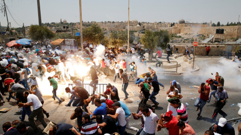 Manifestantes palestinos corren después de que las tropas israelís lanzasen bombas de gas lacrimógeno. REUTERS/Ammar Awad