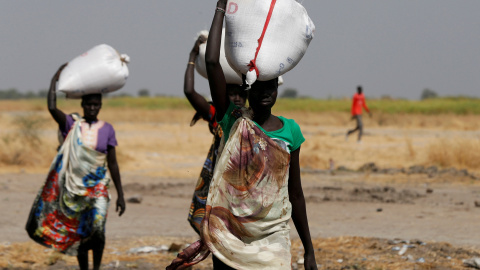 Varias mujeres llevan sacos de alimentos en el pueblo Nimini, en el estado de Unity, al norte de Sudán del Sur.- REUTERS / Siegfried Modola