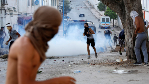 Manifestantes encapuchados lanzan piedras a la Policía antidisturbios durante la multitudinaria protesta en Alhucemas, Marruecos, el pasado 20 de julio.- REUTERS